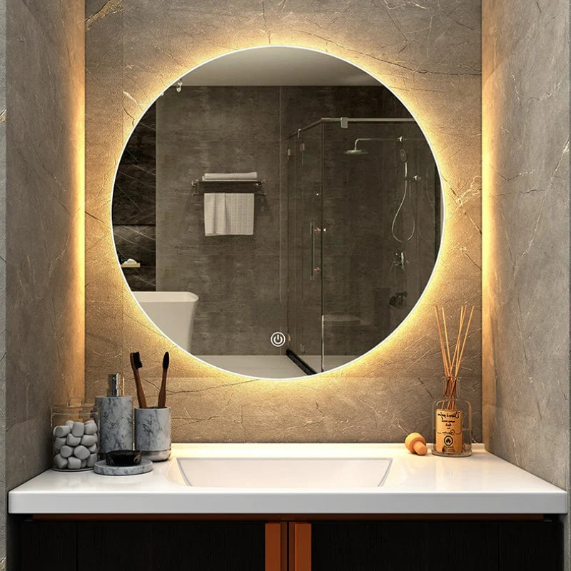 Round illuminated LED bathroom mirror above bathroom vanity